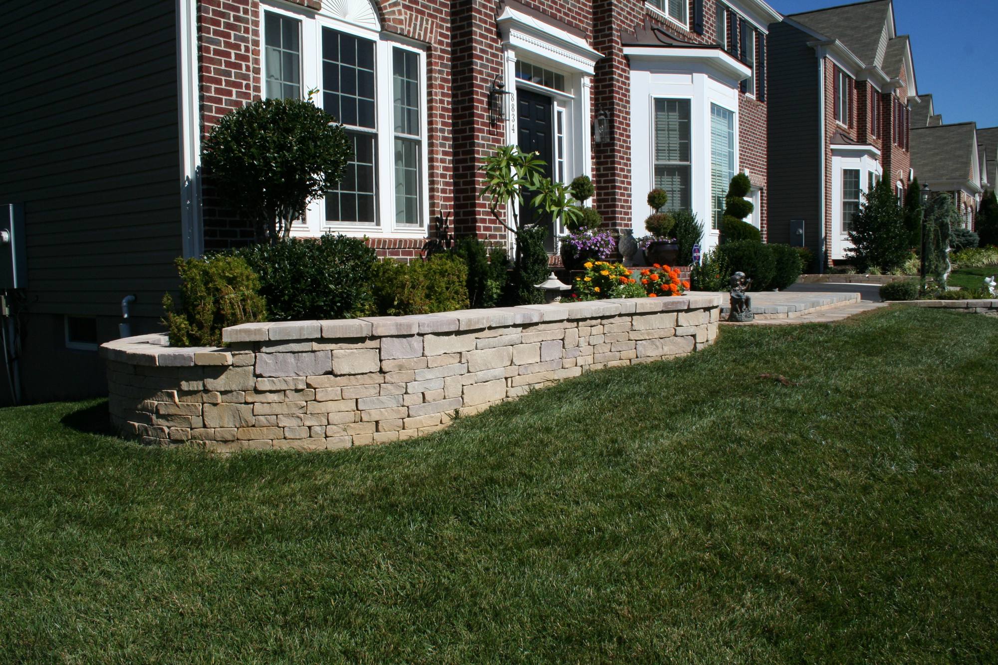 Curved stone planter wall framing a front lawn in Northern Virginia