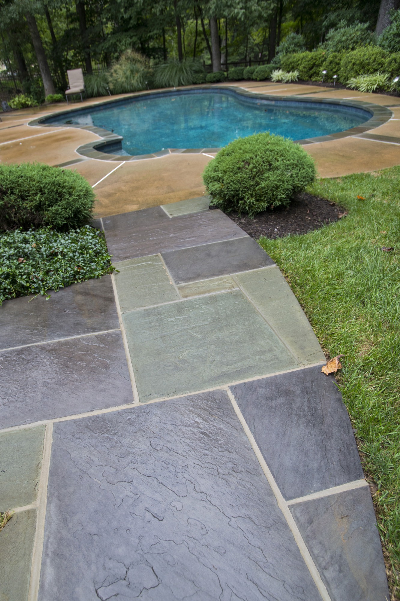 Flagstone walkway leading to an in-ground pool with stone deck in Northern Virginia