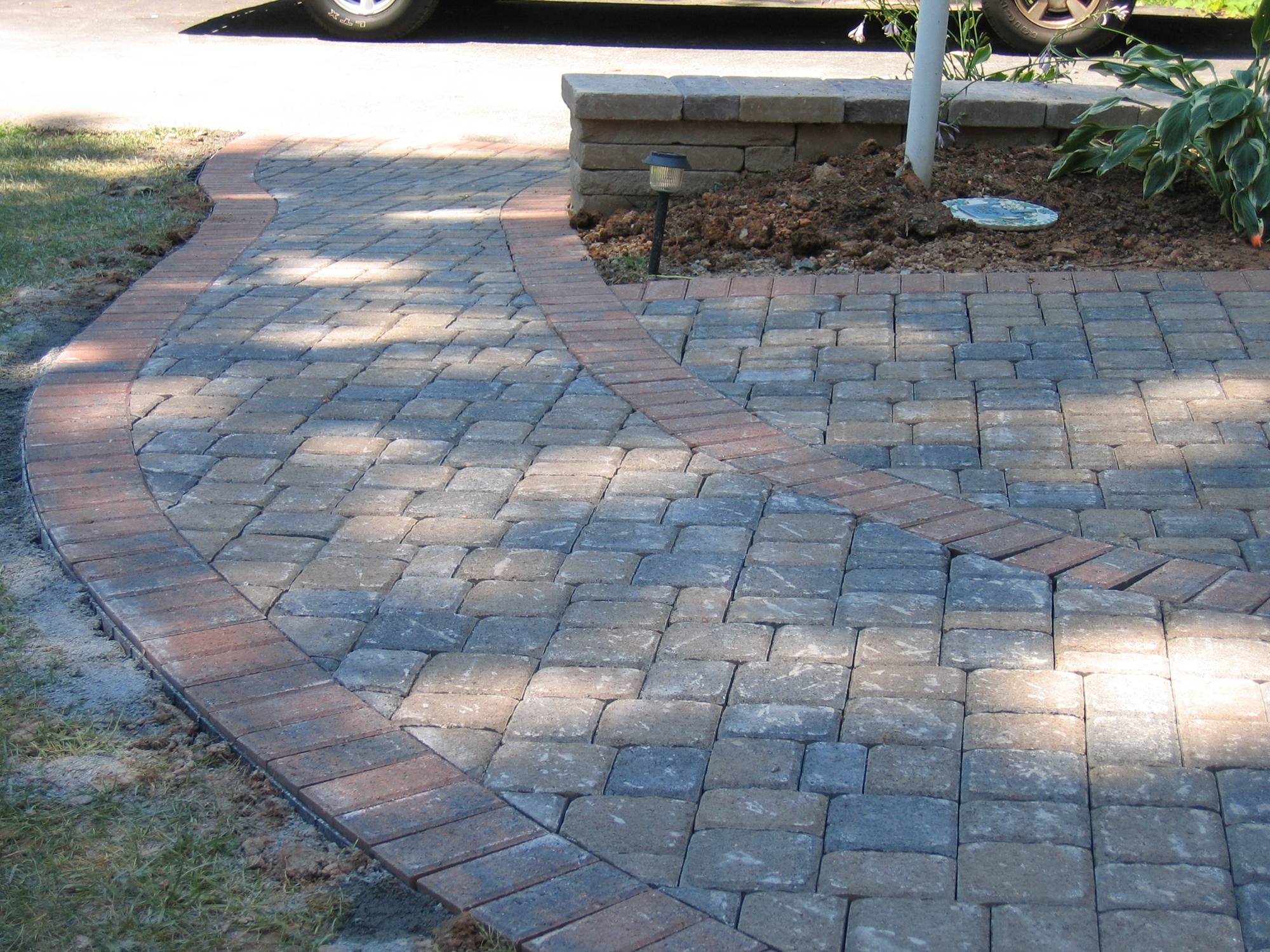 Charcoal paver driveway with brick soldier-course border in Northern Virginia