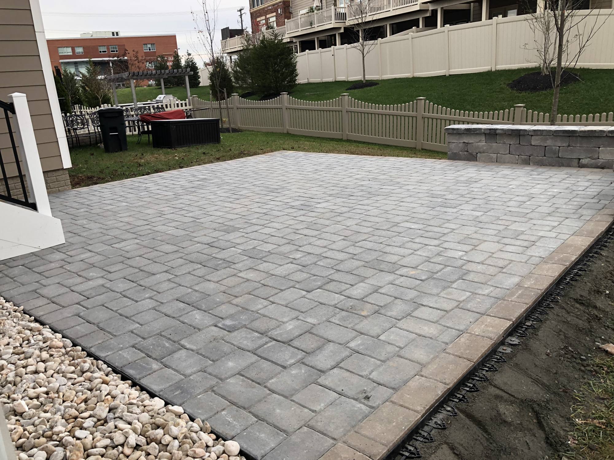 Paver patio with block sitting wall in a fenced Northern Virginia backyard