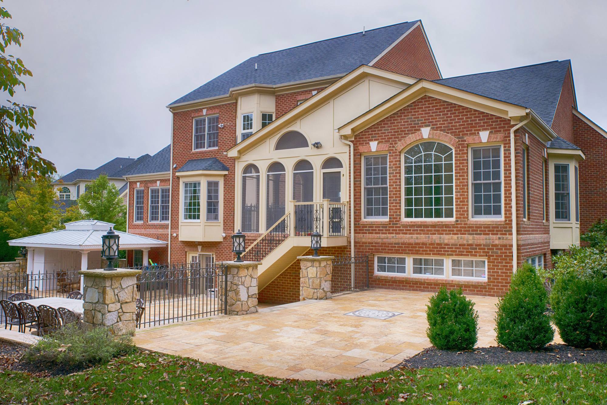 Expansive travertine patio with stone pillars at a brick estate home in Northern Virginia