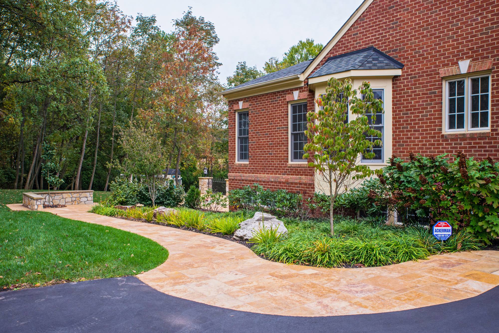 Travertine front walkway curving past landscaped beds in Northern Virginia